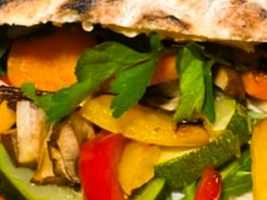 Frisches Gemüse in einer Fladenbrot-Hülle, darunter Paprika, Zucchini und Karotten.